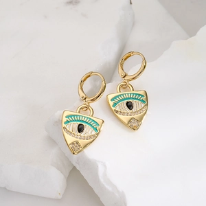 18K gold plated eye earrings with blue enamel, zircon accents on white marble