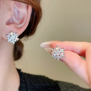 Detailed view of silver snowflake stud earrings with sparkling cubic zirconia and pearls