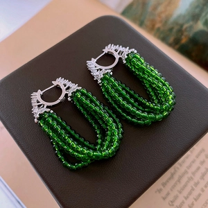 Détail de boucles d'oreilles pampilles à perles vertes avec fermoirs en argent et zircon