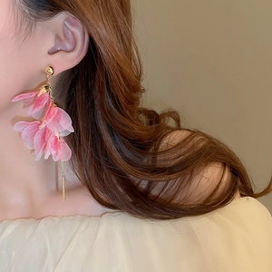 Detail of pink layered petal earrings with long gold tassel shown on model