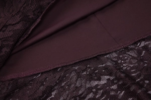 Gros plan sur les motifs de dentelle et la doublure bordeaux aux coutures fines