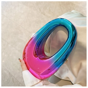 Detailed close-up of pink and blue gradient acrylic clutch bag with golden chain strap