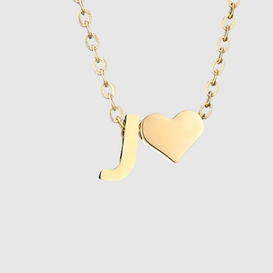 Macro de l'acier inoxydable doré avec pendentif en forme de cœur et de la lettre J