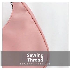 Macro detail of high-quality sewing thread on a pink nylon crossbody dumpling bag