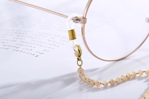 Detail of champagne gold eyewear chain with faceted beads and adjustable silicone loops