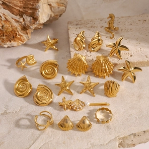 Golden starfish and seashell jewelry set with pearl accents on a natural stone background