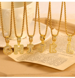 Close-up of gold-plated letter pendants G to L with shimmering zircon micro-inlays