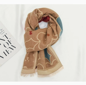 Close-up of soft knitted scarf with geometric floral patterns and fringe details