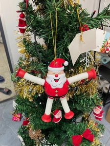 Detail of Santa Claus pop tube toy hanging on a Christmas tree with a golden string