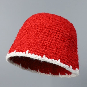 Detailed macro view of red crochet knit hat showing thick handmade wool texture and white trim
