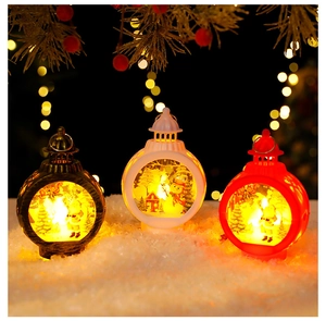 Three LED Christmas lanterns in black, white, and red on snow with warm festive lights