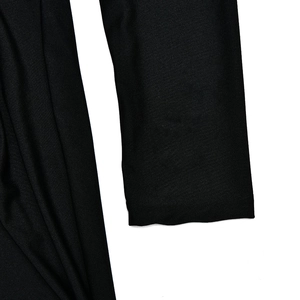 Gros plan du poignet noir à manches longues et texture plissée sur la robe chic