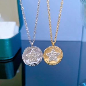 Close-up of gold and silver necklaces with pentagram star pendants on reflective surface
