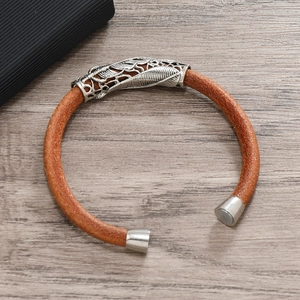 Detailed view of brown braided leather bracelet with silver feather metal charm and clasp