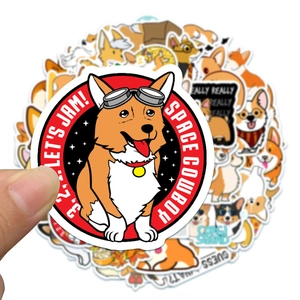 Hand holding a cute Corgi sticker from a 50-piece waterproof PVC laptop decal set