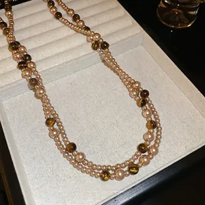 Collana a doppio strato con occhio di tigre e perle su vassoio per gioielli in velluto