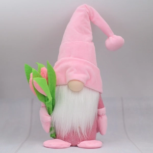 Detailed view of pink plush gnome doll with soft white beard and green felt flower bouquet