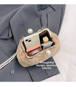 Detailed view of beige plush shell bag with large pearl clasp and internal storage space