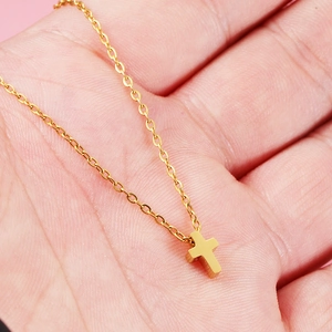 Minimalist gold stainless steel cross necklace on hand with a delicate O-chain