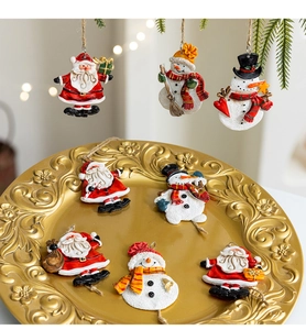 Detailed view of hand-painted resin Santa and snowman ornaments on a vintage gold tray