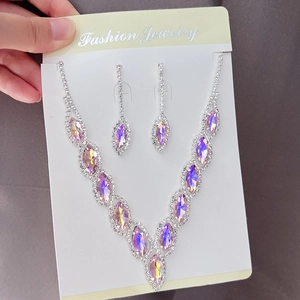 Detail of silver bridal necklace and earrings set with pink and purple crystals