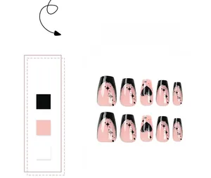 Détail des faux ongles trapèze noir et rose avec des motifs d'étoiles et de cœurs