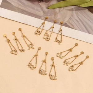 Détail de boucles d'oreilles zodiaque en or 18K avec zircon blanc et chaînes longues
