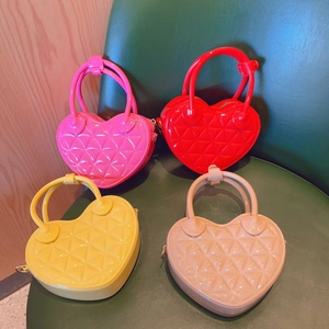 Top view of four colorful heart-shaped PVC jelly handbags in pink, red, yellow and beige