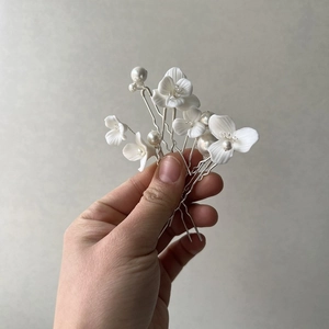 Elegant bridal hair pins set with white ceramic flowers and pearls on silver metal base