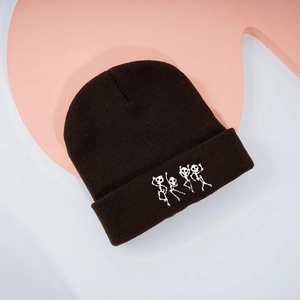 Détail de la broderie squelette dansant sur le bonnet en maille côtelée gris foncé
