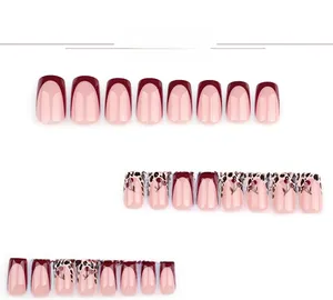 Détails de faux ongles French rouges avec motifs léopard et dessins de cerises