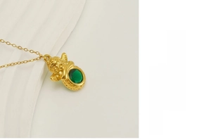 Detailopname van de 18k vergulde engel hanger met een groene ovale edelsteen inzetstuk