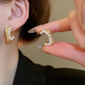Elegant C-shaped hoop earrings with white pearls and small diamonds in golden finish