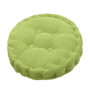 Close-up of a light green round corn velvet chair cushion with button tufting design