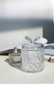 Close-up of elegant embossed butterfly patterns on transparent glass storage jar
