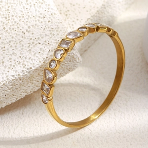 18K gold plated geometric bangle featuring multi-shape zircons on a white stone background