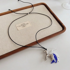 Silver horse pendant necklace with blue bead tail on a black cord with luxury finish