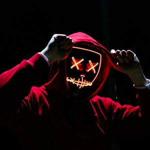 Macro detail of red LED glowing mask with X-shaped eyes and stitched mouth design