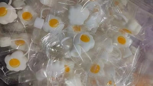 Bulk package of fried egg silicone straw toppers in individual clear plastic bags