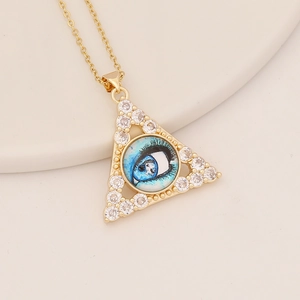 Goldene Dreieckskette mit blauem Auge und Zirkonia-Inlay auf beigem Display