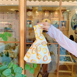 Japanese knot bag with cartoon lion print in natural cotton canvas on model wrist