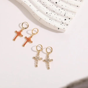Detail of 14K gold plated cross earrings with orange and white cubic zirconia stones