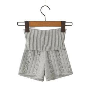 Détail d'un short en maille gris clair avec torsades et taille haute côtelée