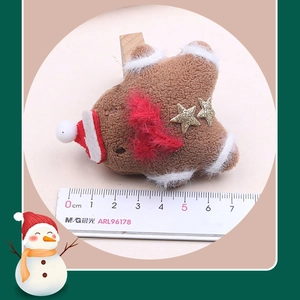 Detail of plush gingerbread star hair clip with mini Santa hat and wooden clip backing