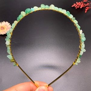 Macro detail of handmade green crystal quartz crown headband with golden wire wrap