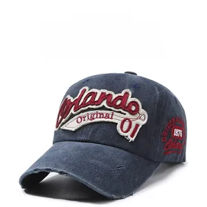 Detail of red and white 3D embroidery and washed denim texture on navy baseball cap
