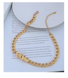Detailed view of 18k gold plated Cuban chain necklace with D-ring clasp on white plate