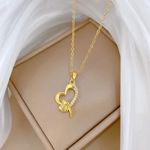 Luxurious gold heart necklace with sparkling crystals on a textured leather box