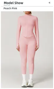 Détail d'un ensemble de sport rose pêche sans couture avec haut zippé et passe-pouces