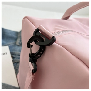 Close-up of durable black swivel hook and zipper detail on a pink nylon yoga sports bag